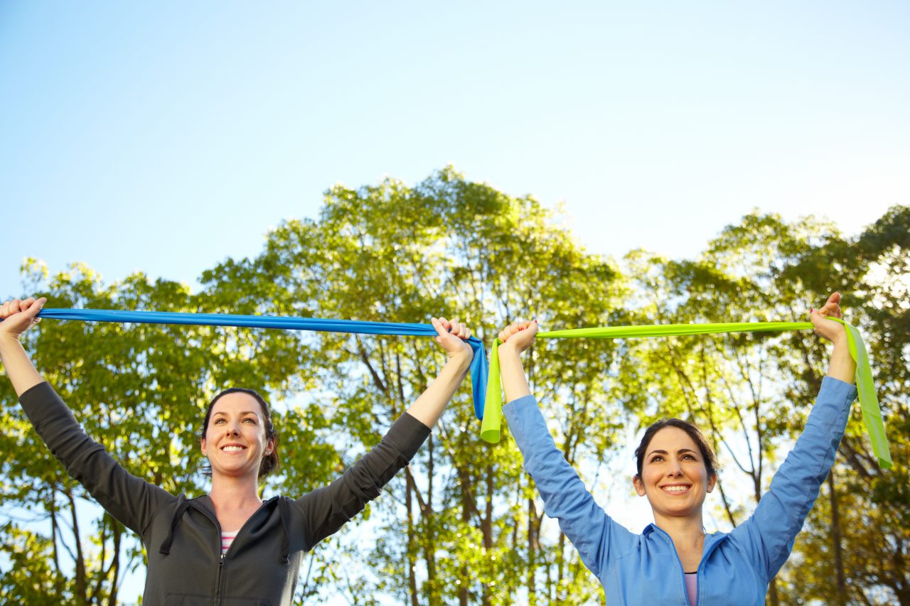 Two women stretch band