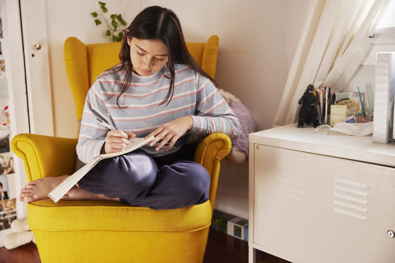 Young woman writing in journal