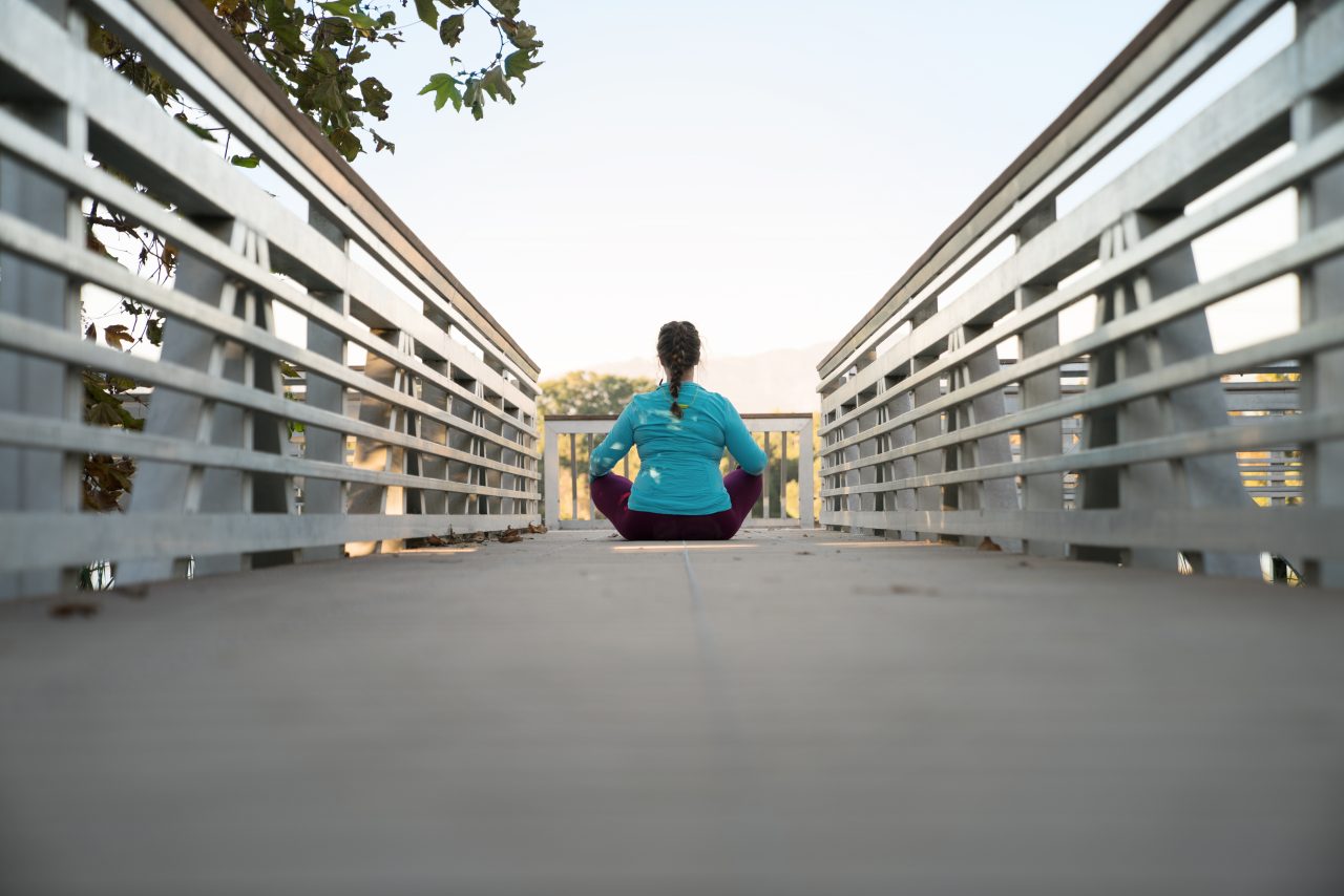 Woman doing yoga on bridge